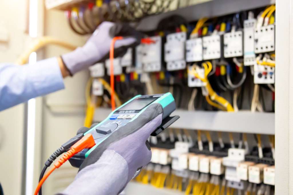 Engineer using a multimeter to assess electrical equipment